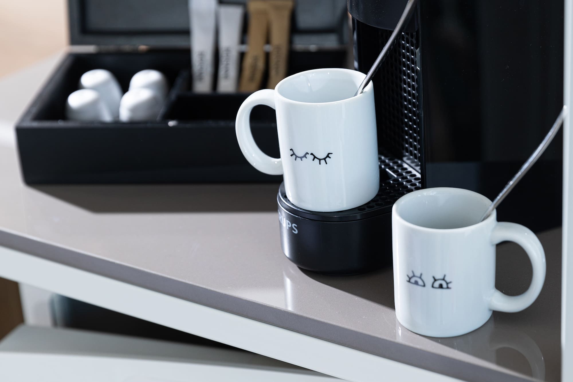 a coffee machine and mugs on a table