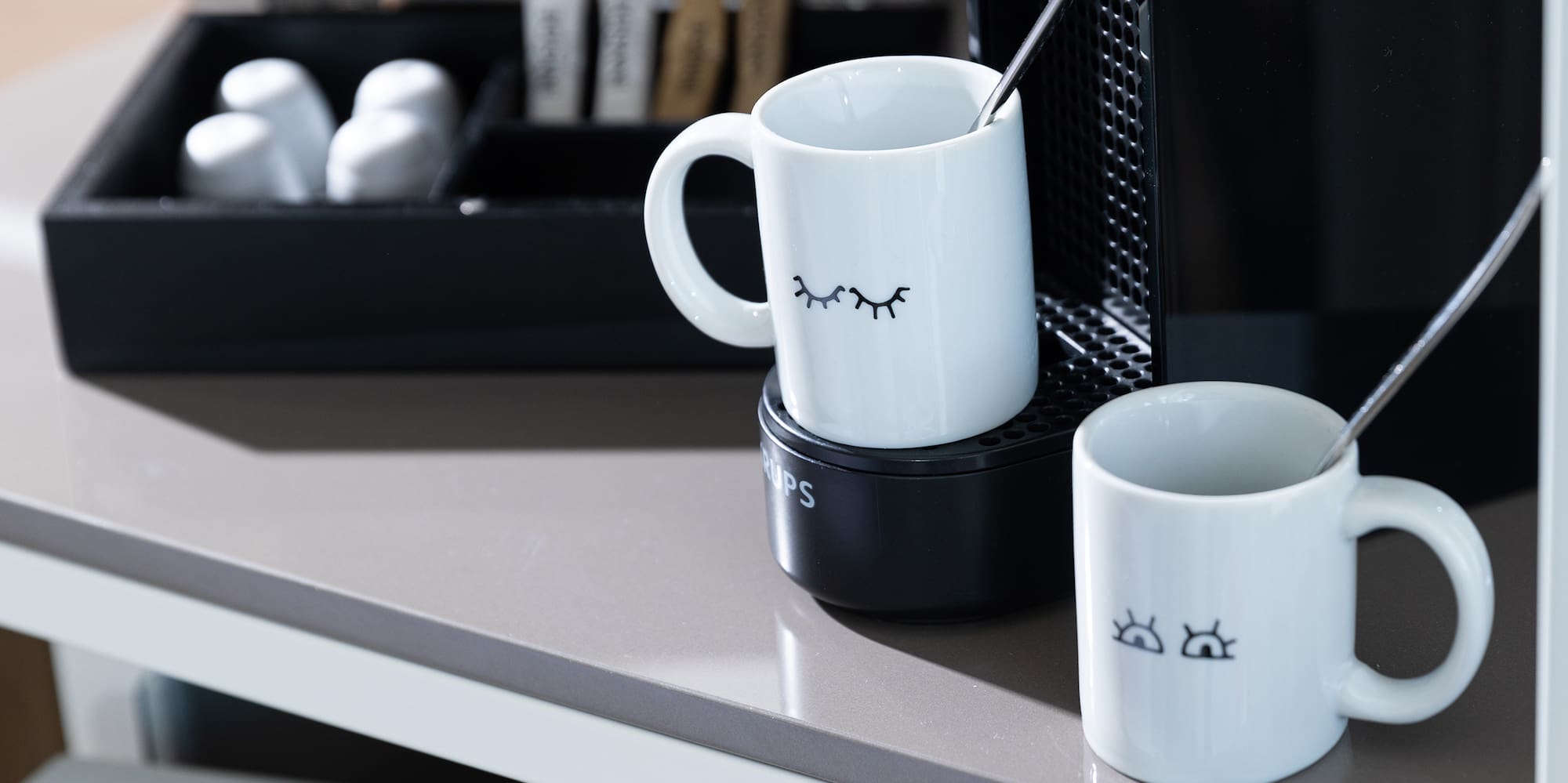 a coffee machine and mugs on a table