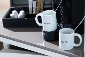 a coffee machine and mugs on a table
