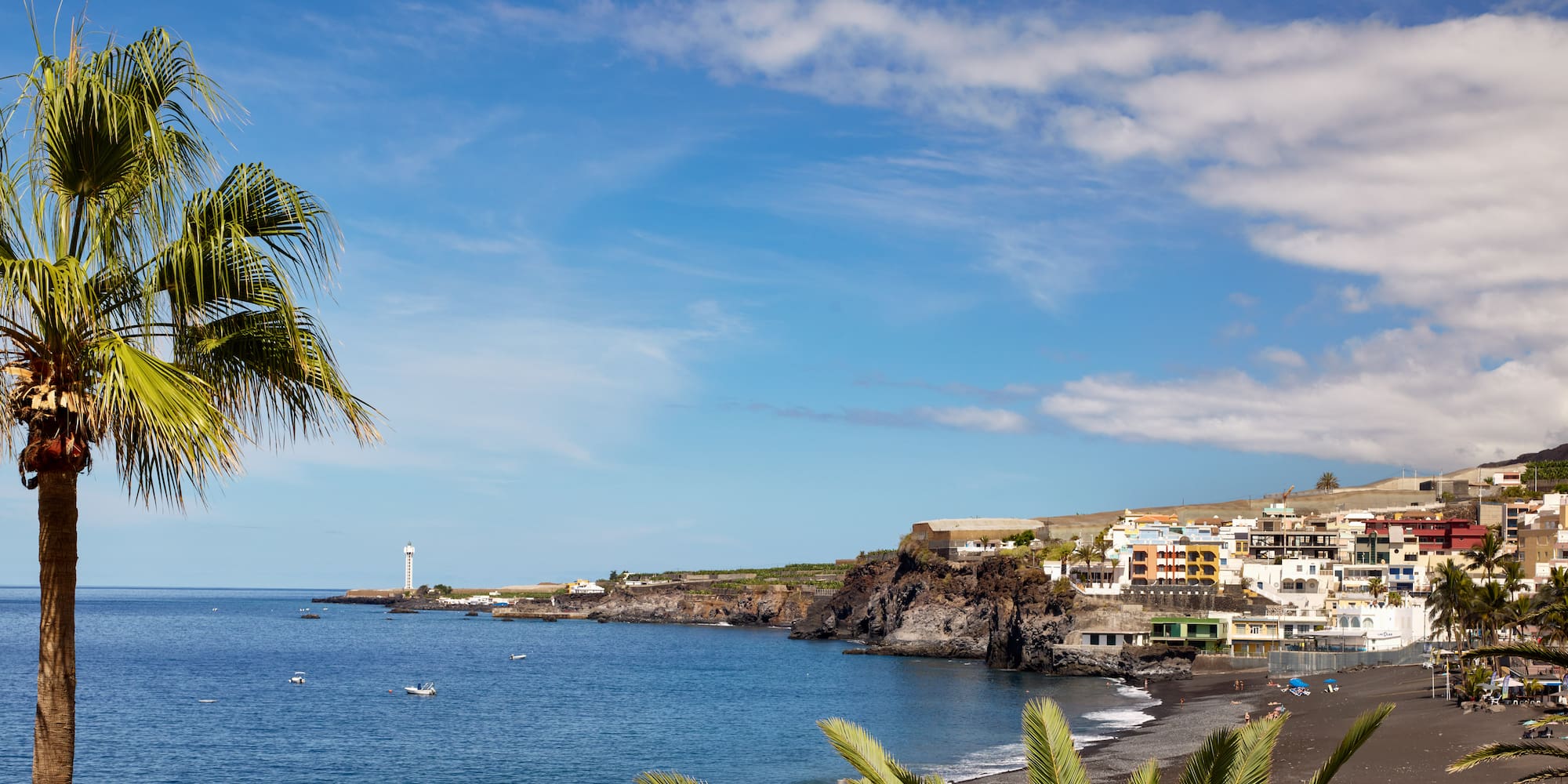 a beach with a body of water and buildings