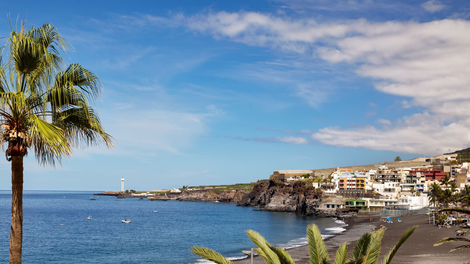 a beach with a body of water and buildings