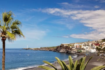 a beach with a body of water and buildings