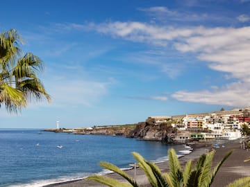 a beach with a body of water and buildings