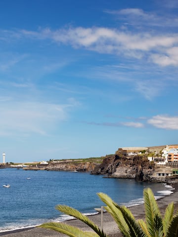 a beach with a body of water and buildings