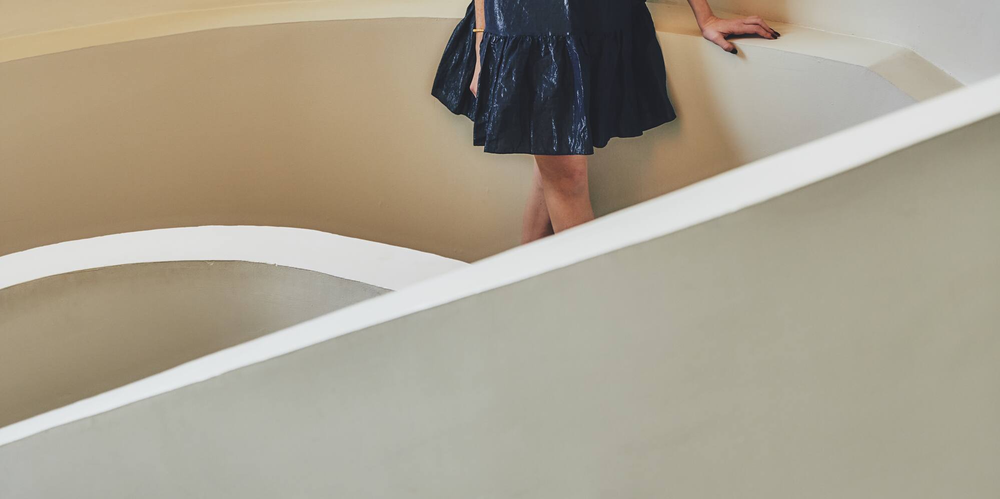 a woman standing in a white spiral staircase