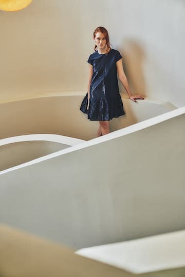 a woman standing in a white spiral staircase