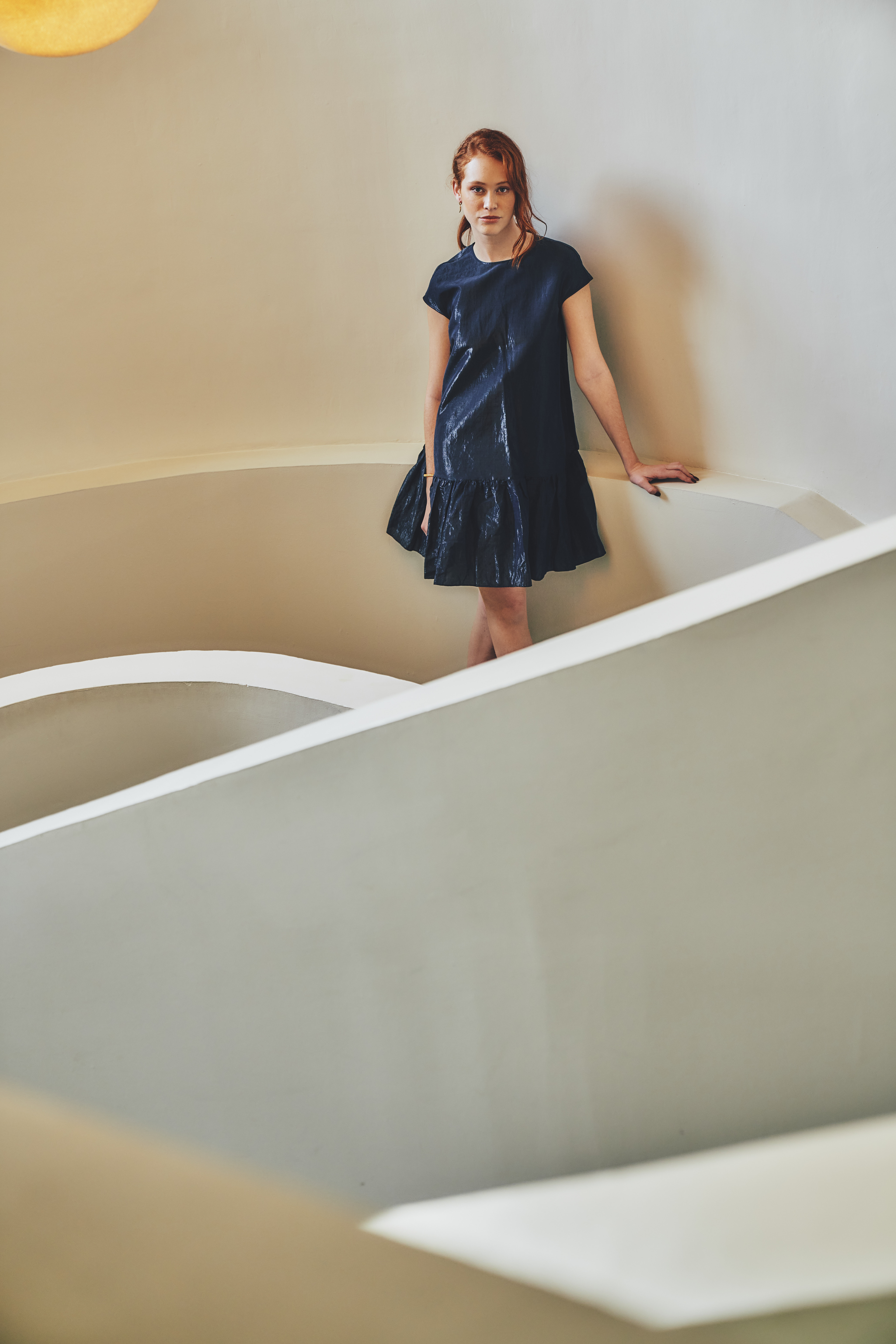 a woman standing in a white spiral staircase