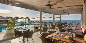 a restaurant with tables and chairs and a pool