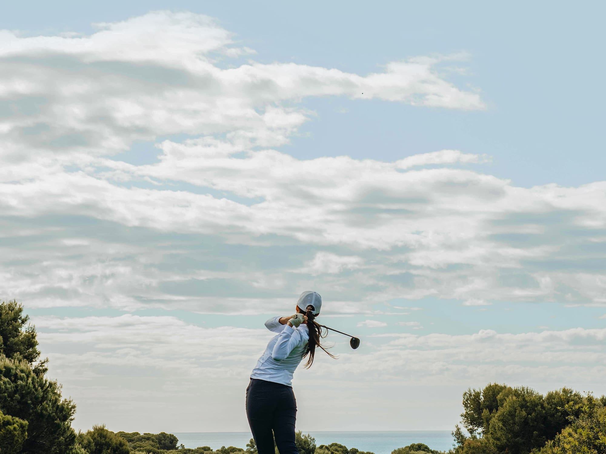 a person swinging a golf club