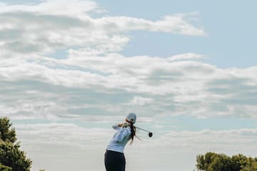 a person swinging a golf club