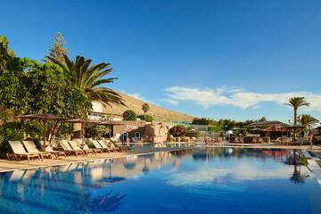 a pool with lounge chairs and trees