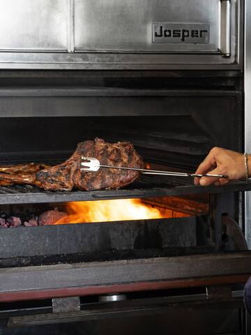 a person cooking meat on a grill