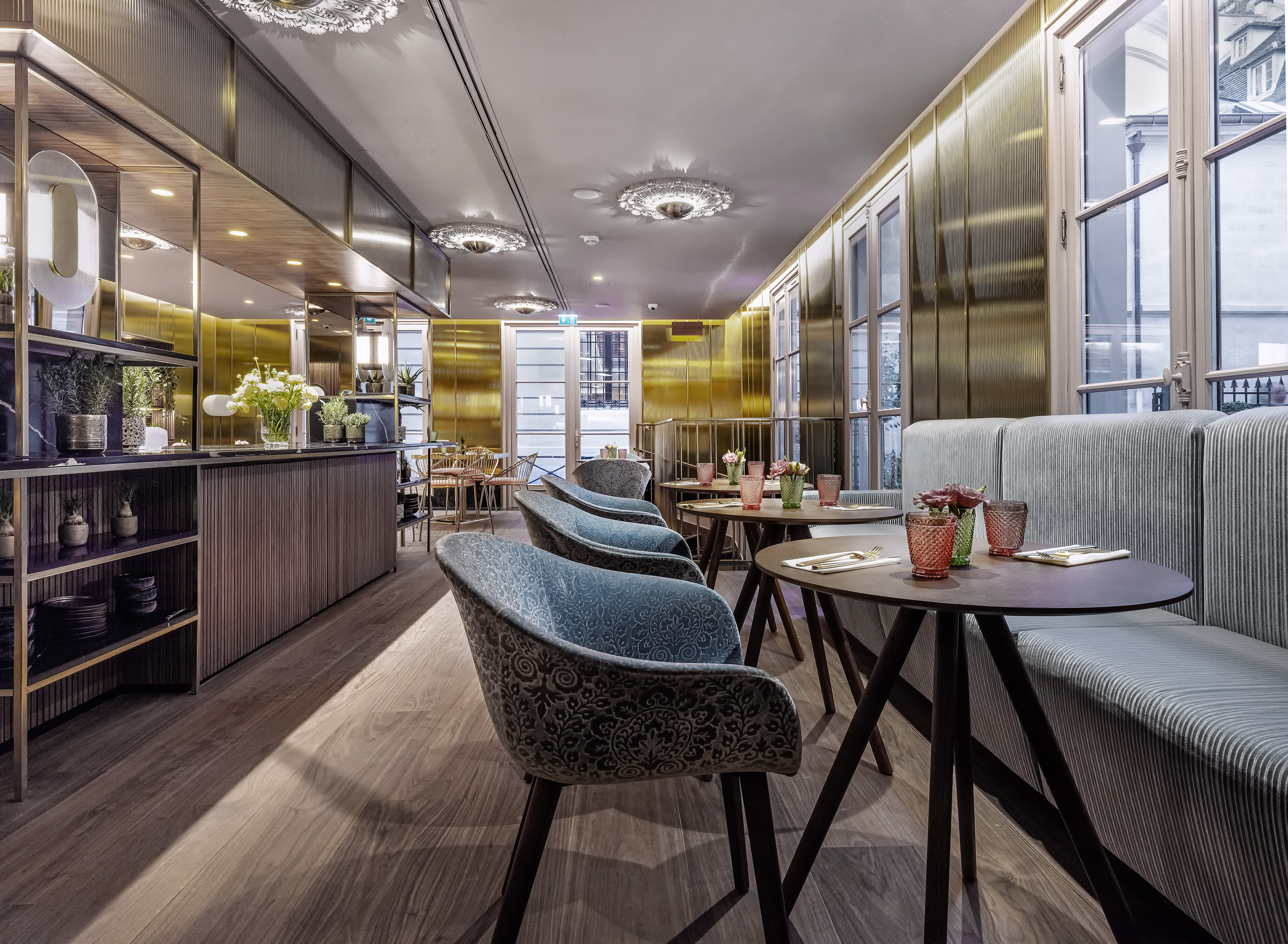 Modern restaurant interior with golden walls, elegant seating, and dining tables.