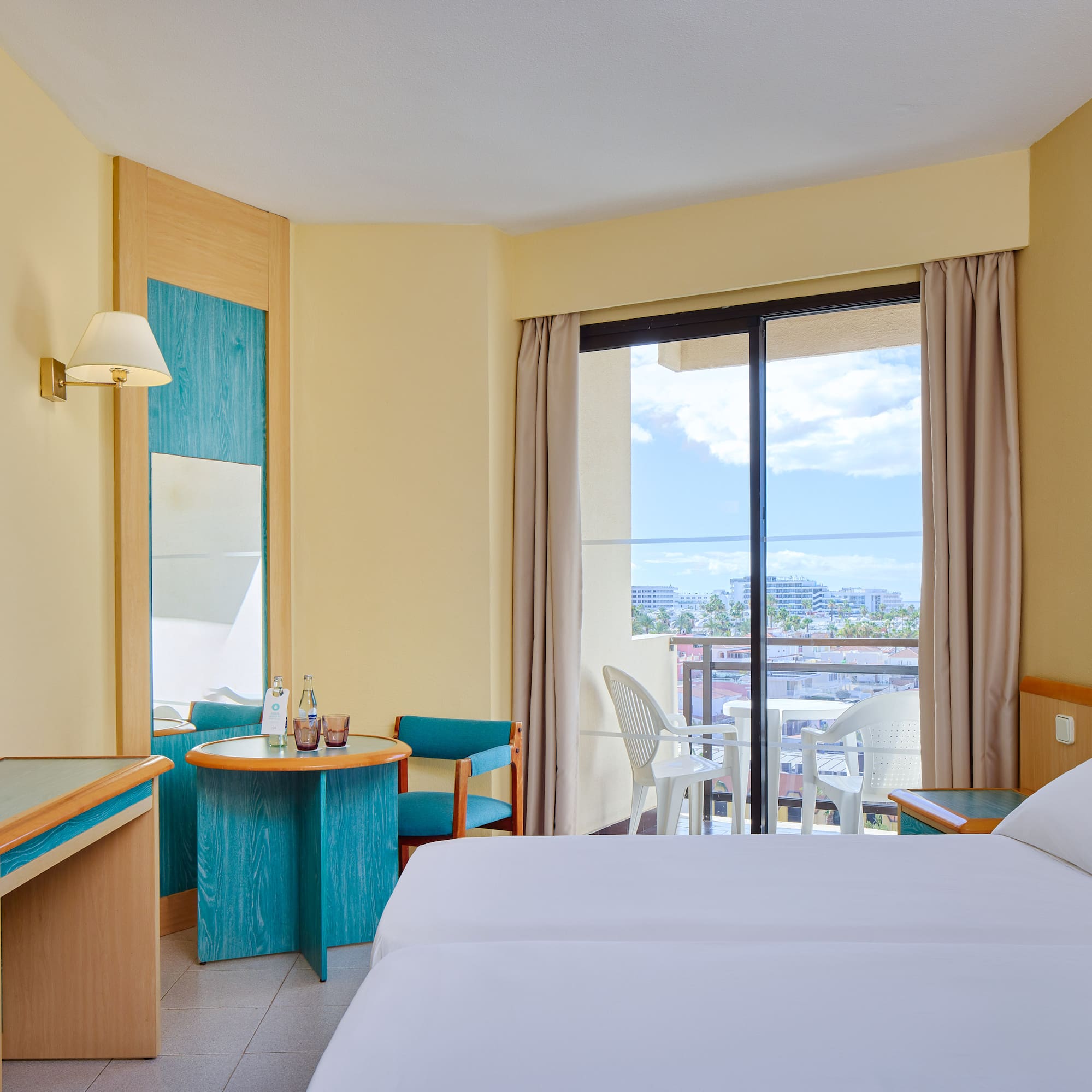 a room with two beds and a table and chairs