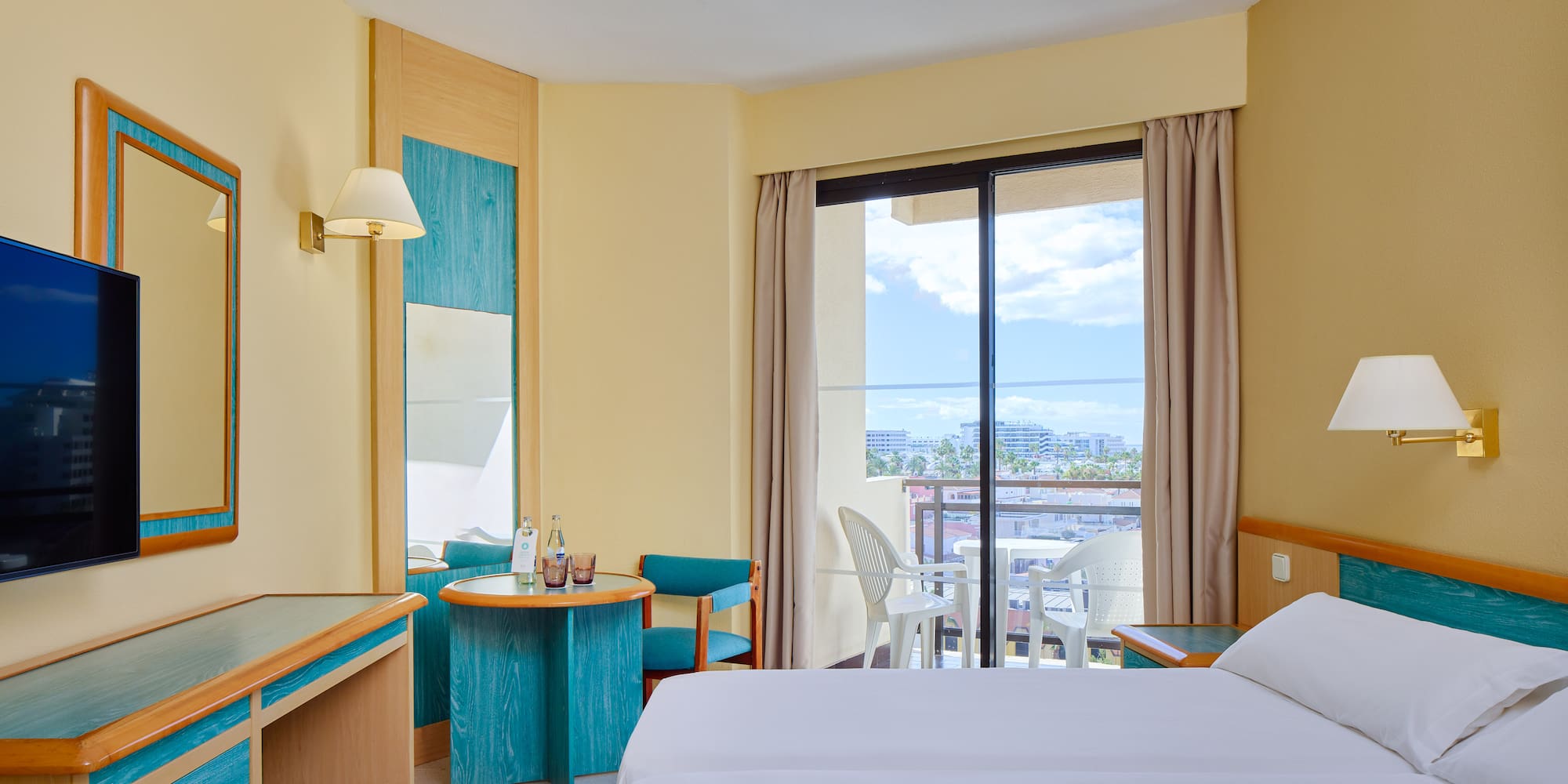 a room with two beds and a table and chairs