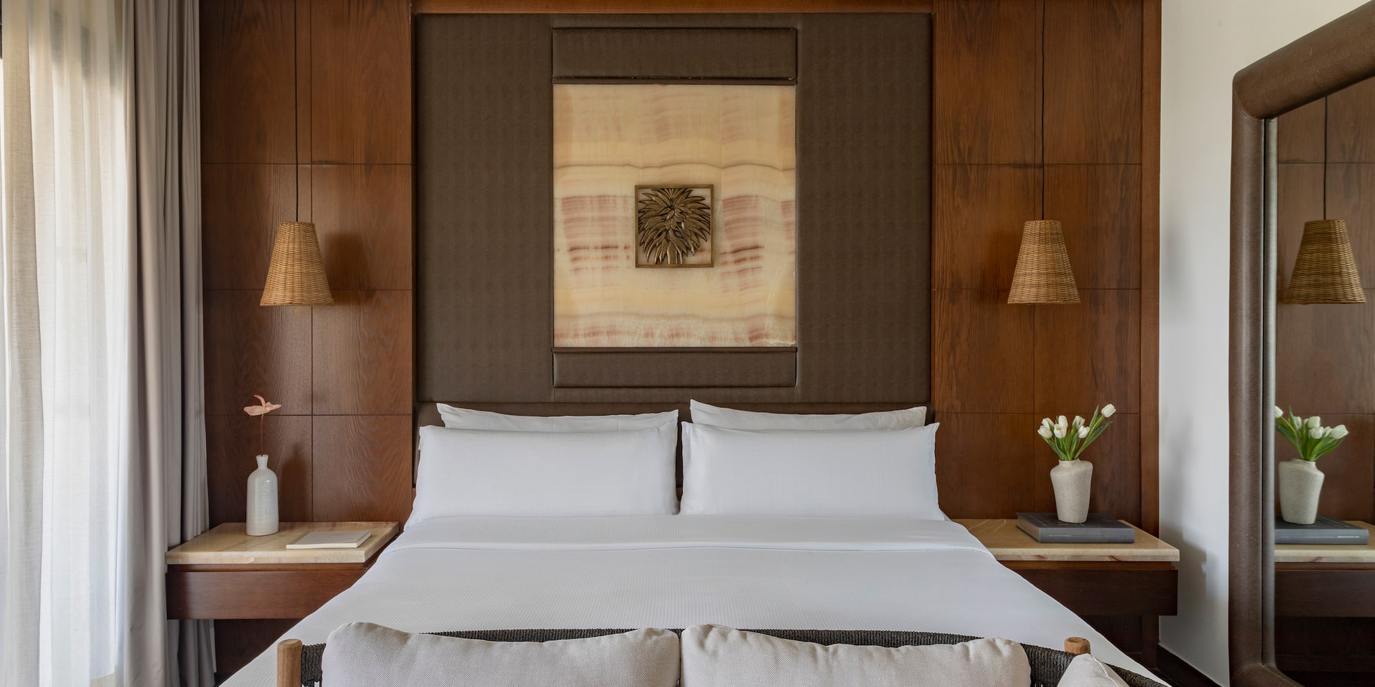 a bed with white sheets and pillows in a room