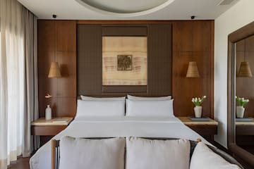 a bed with white sheets and pillows in a room