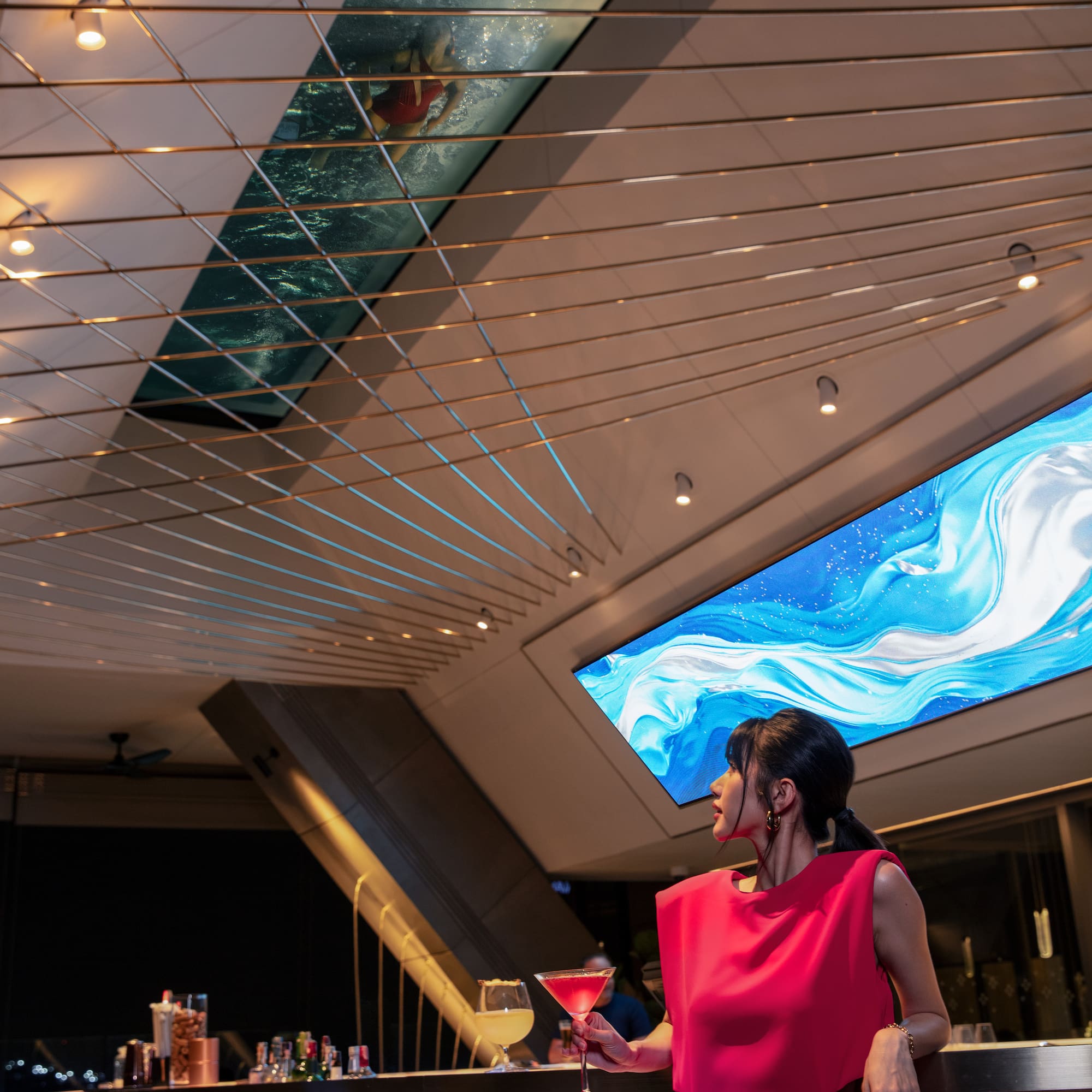 a woman in a red dress standing at a bar