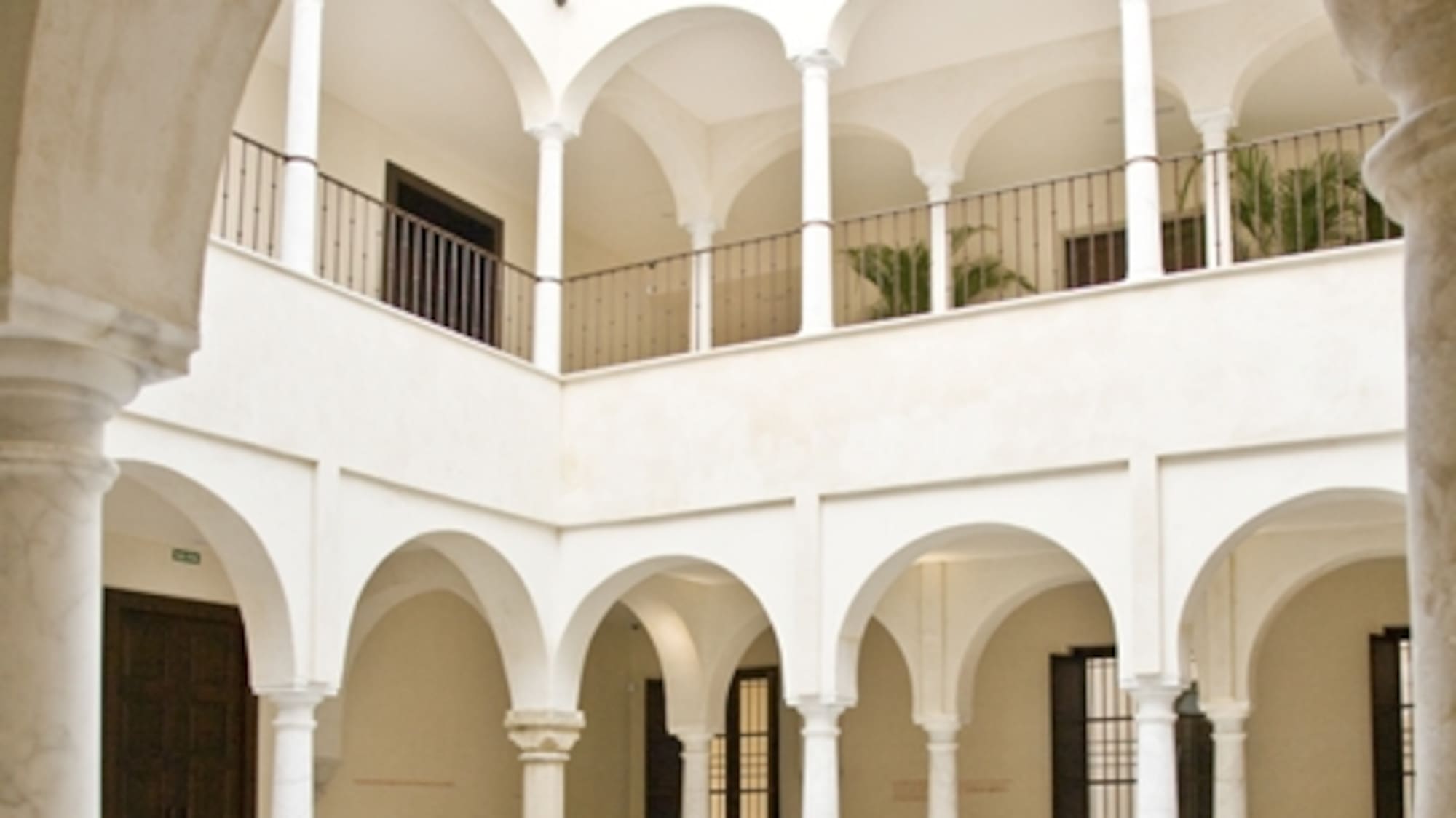 a white building with arches and flowers