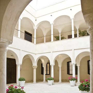 a white building with arches and flowers
