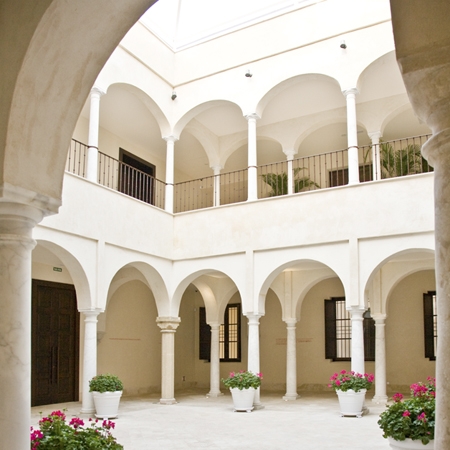 a white building with arches and flowers