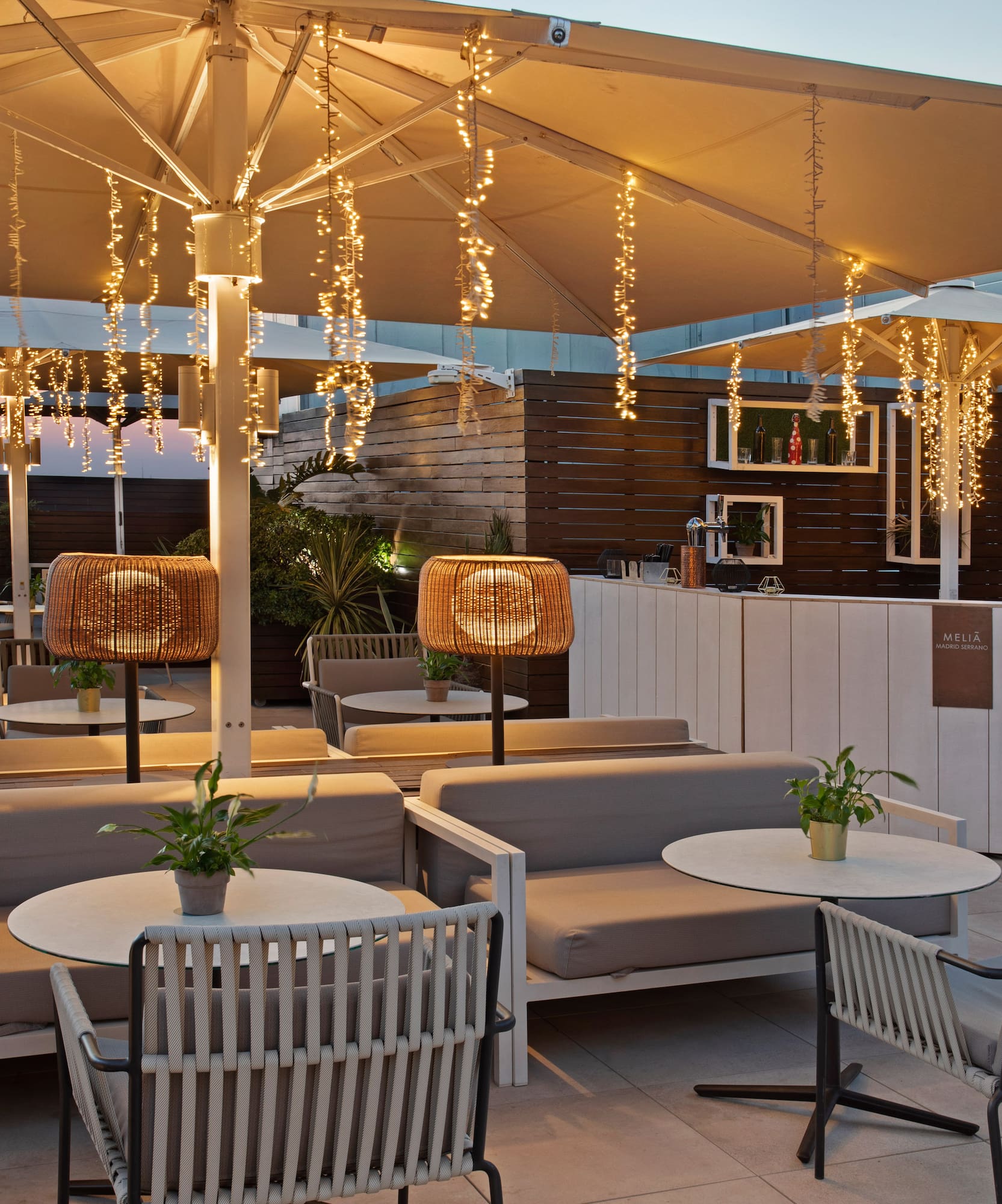 a patio with tables and chairs and lights