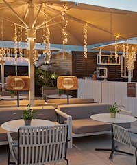 a patio with tables and chairs and lights