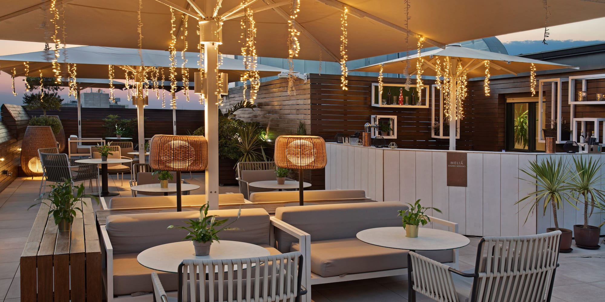 a patio with tables and chairs and lights