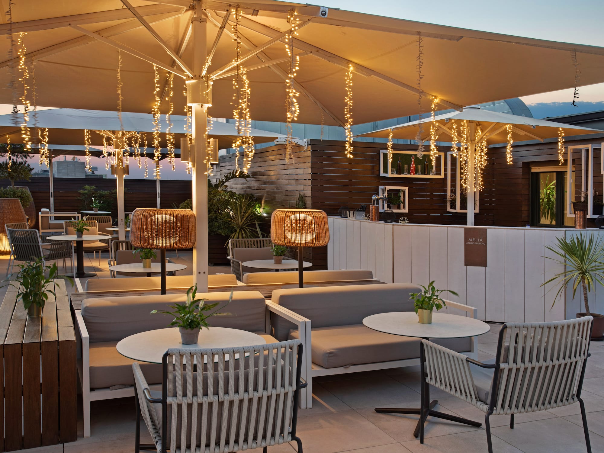 a patio with tables and chairs and lights