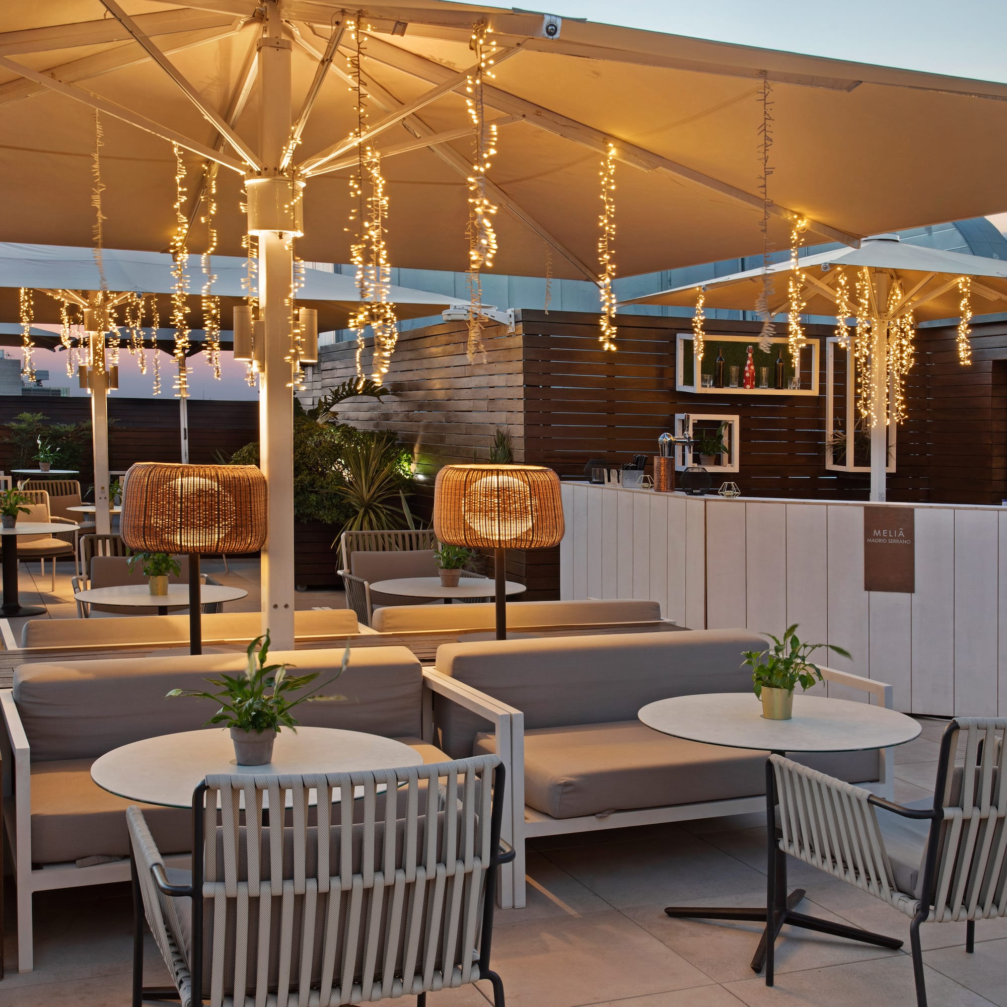 a patio with tables and chairs and lights
