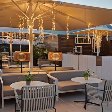 a patio with tables and chairs and lights