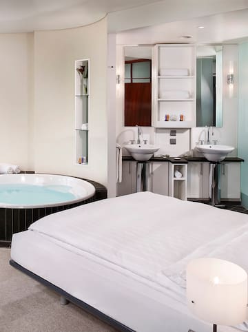 a bathroom with a bathtub and a bed
