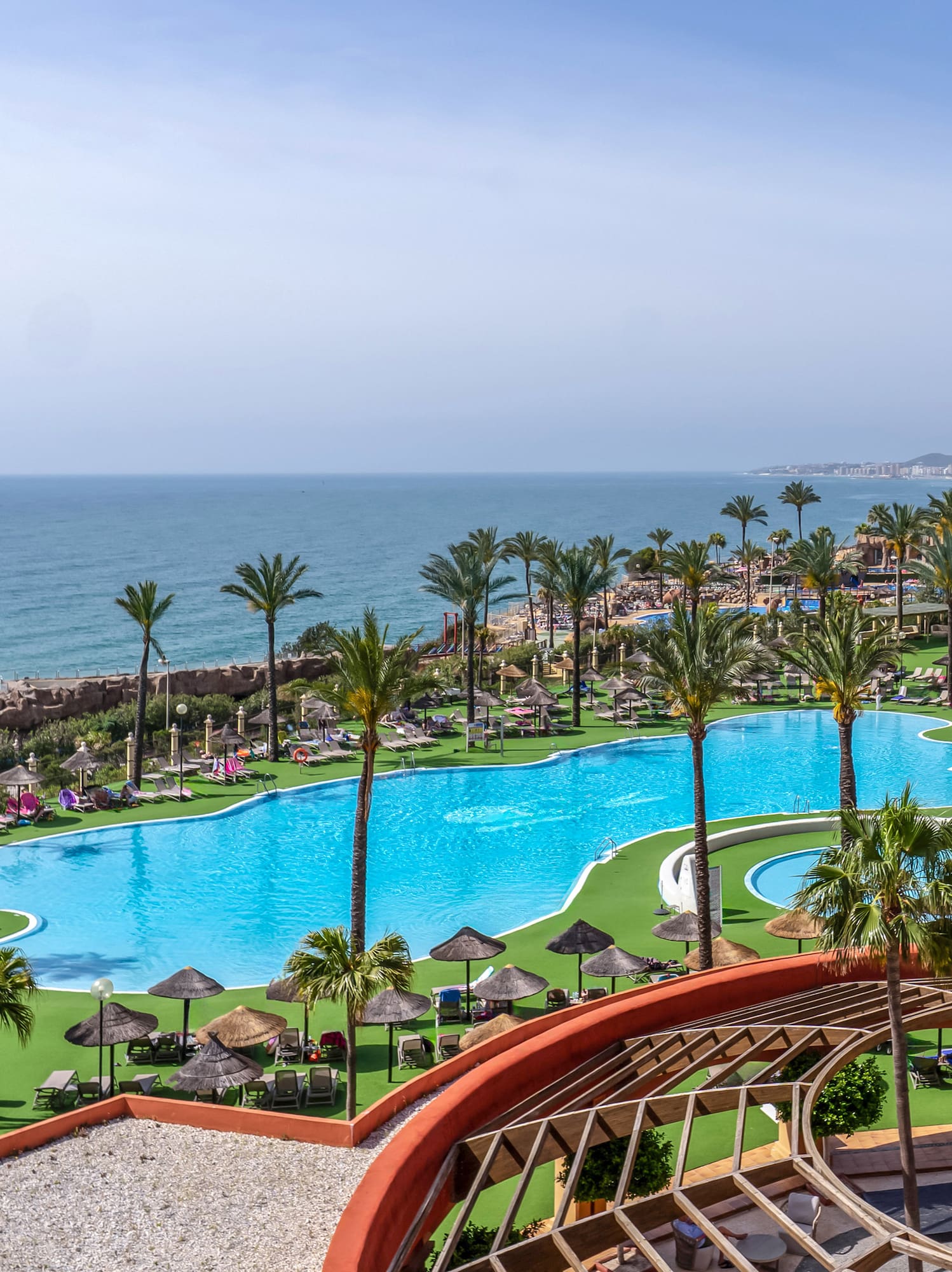 a pool with palm trees and a beach