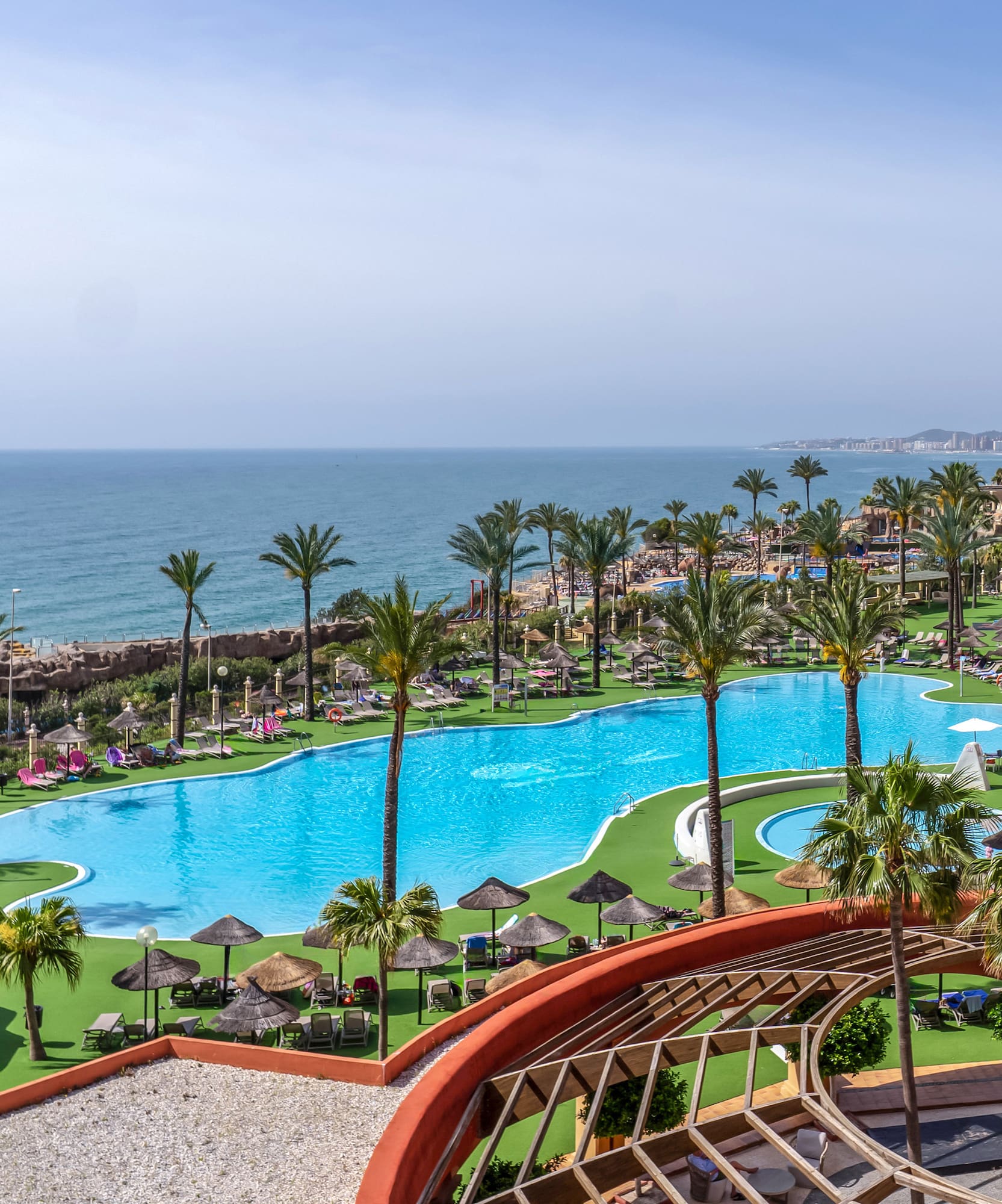 a pool with palm trees and a beach