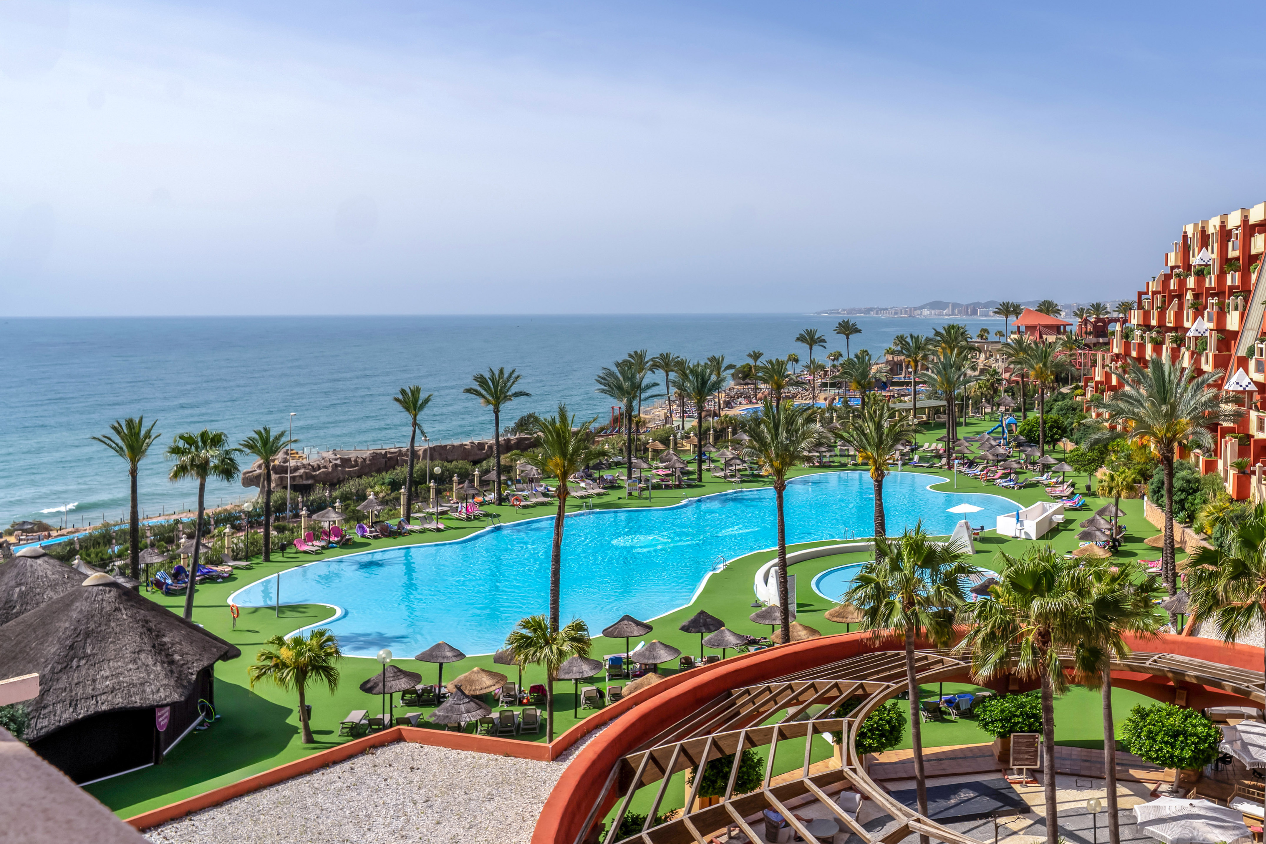 a pool with palm trees and a beach