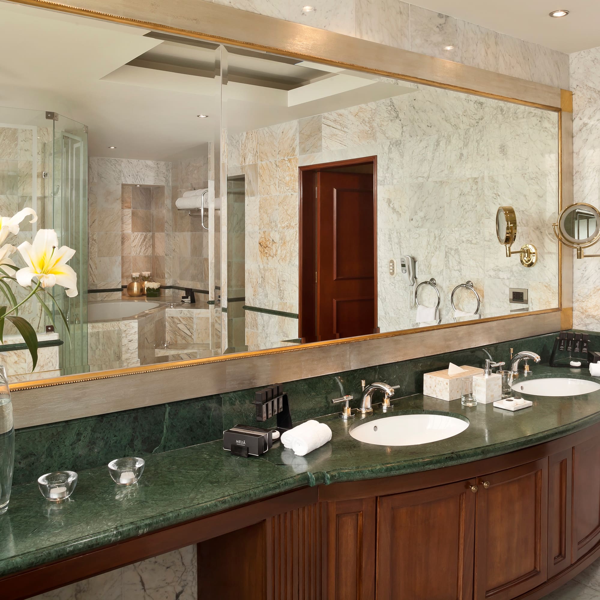 a bathroom with marble countertop and large mirror