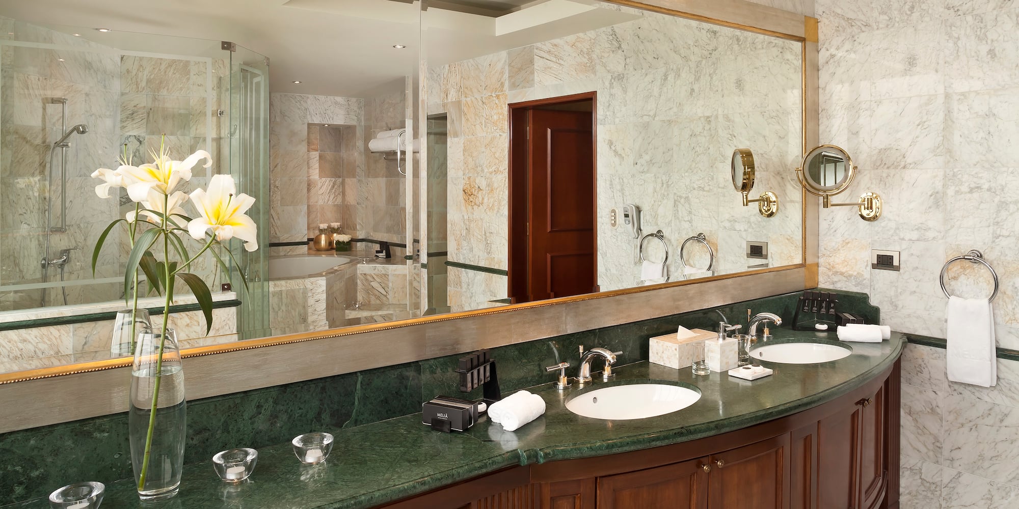 a bathroom with marble countertop and large mirror