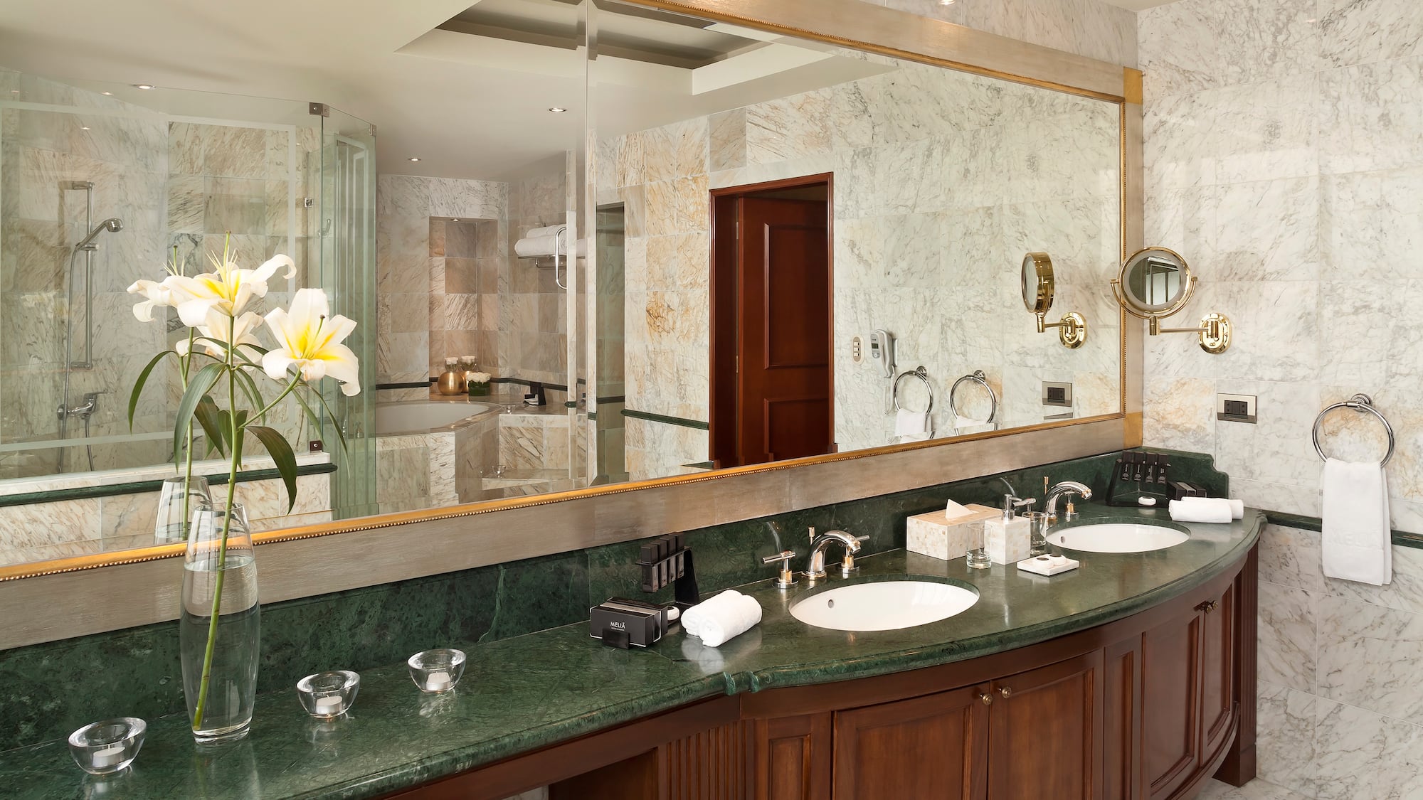 a bathroom with marble countertop and large mirror