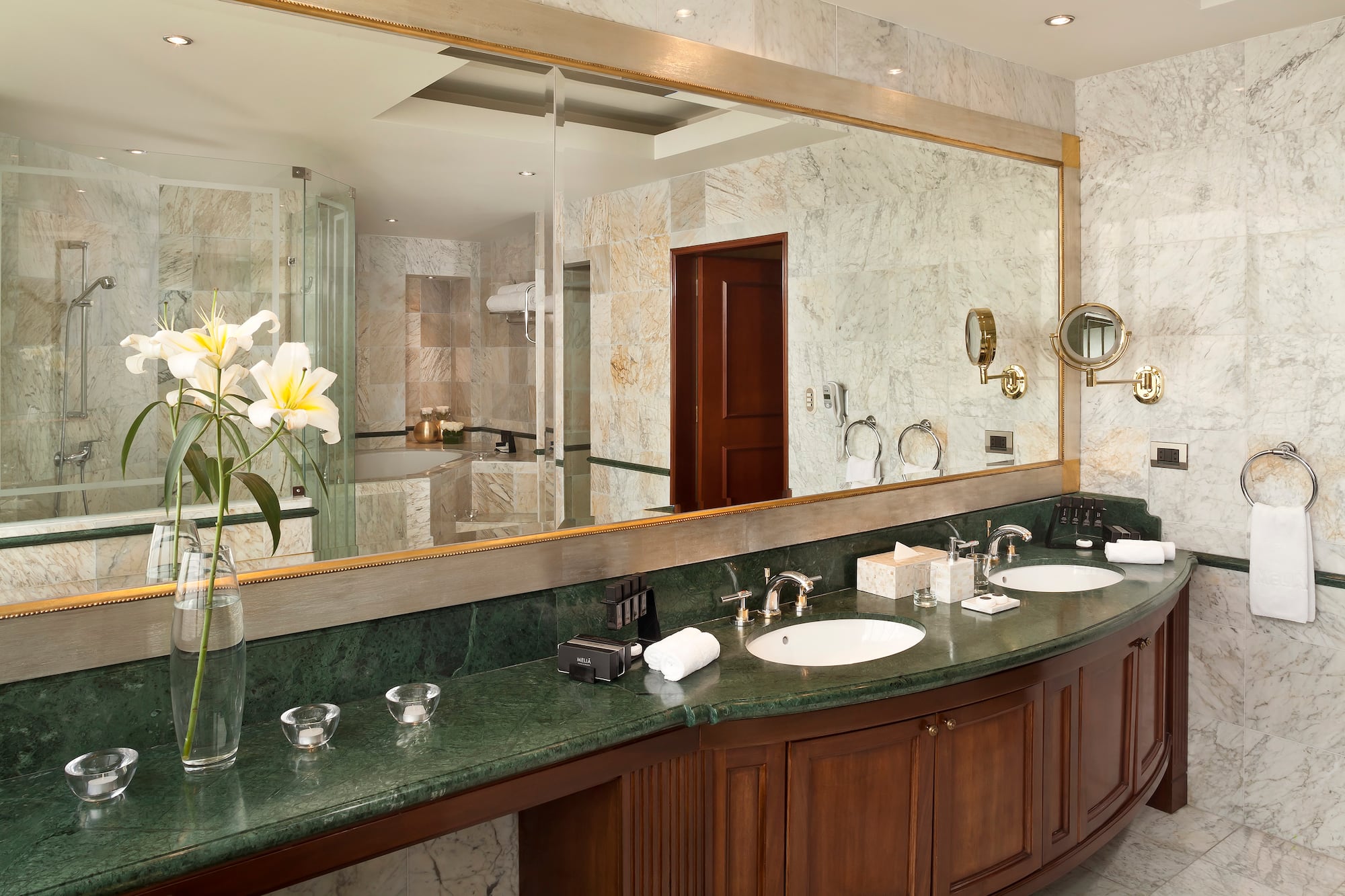 a bathroom with marble countertop and large mirror