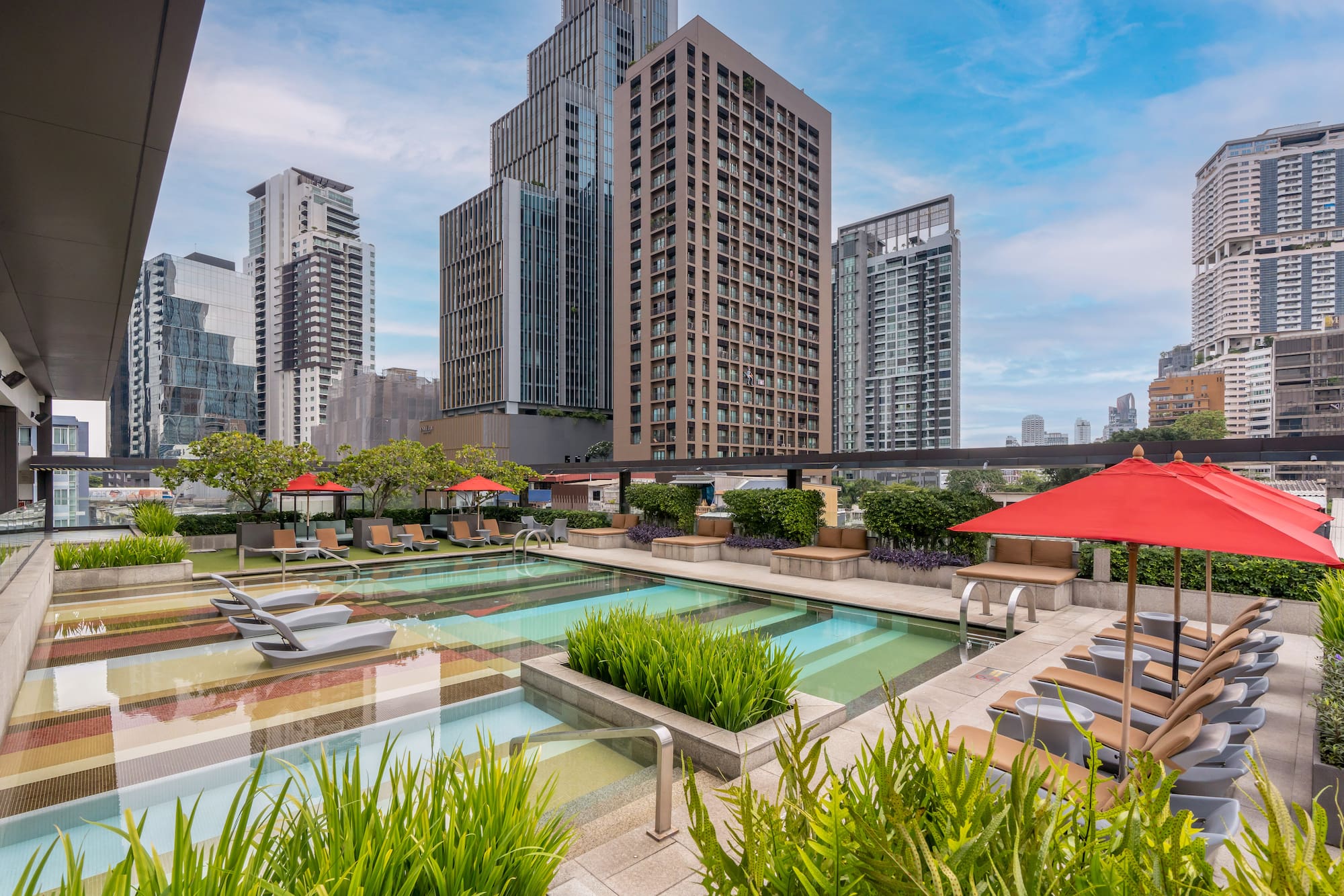 Rooftop swimming pool and lounge area with skyscrapers in Bangkok skyline. - Outdoor pool - The Hotel Bangkok Sukhumvit 26 Affiliated by Meliá, Bangkok