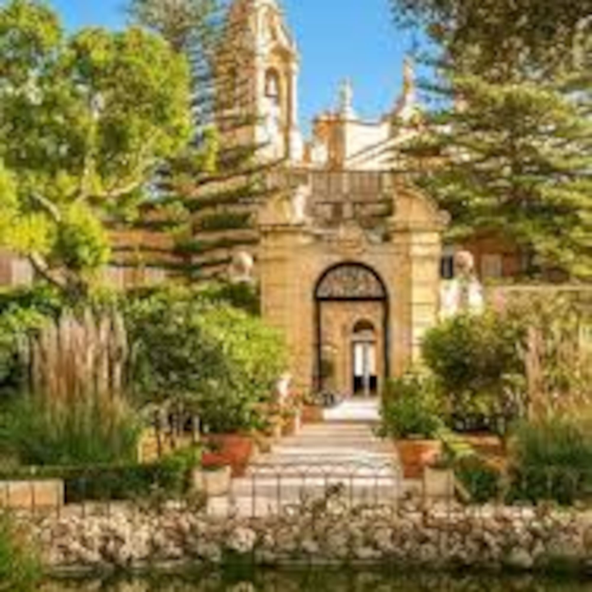 San Anton Palace Malta, baroque architecture, lush gardens, and reflective pond.
