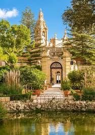 San Anton Palace Malta, baroque architecture, lush gardens, and reflective pond.