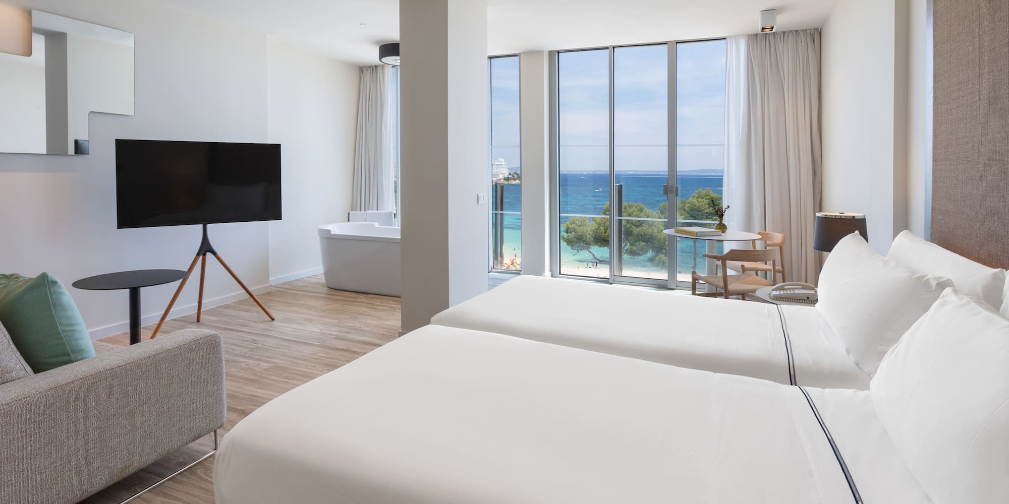 a room with two beds and a tub and a television