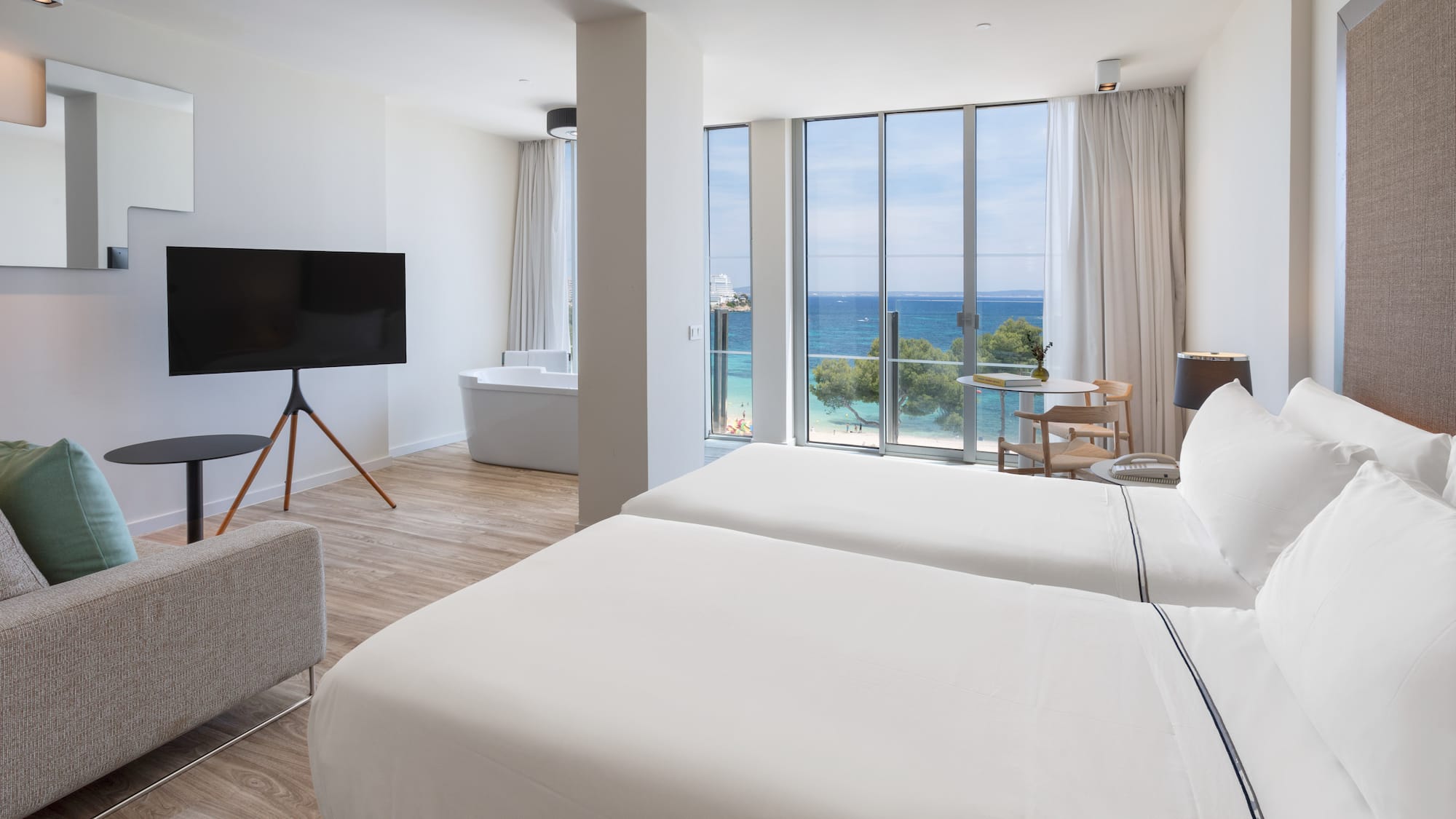 a room with two beds and a tub and a television