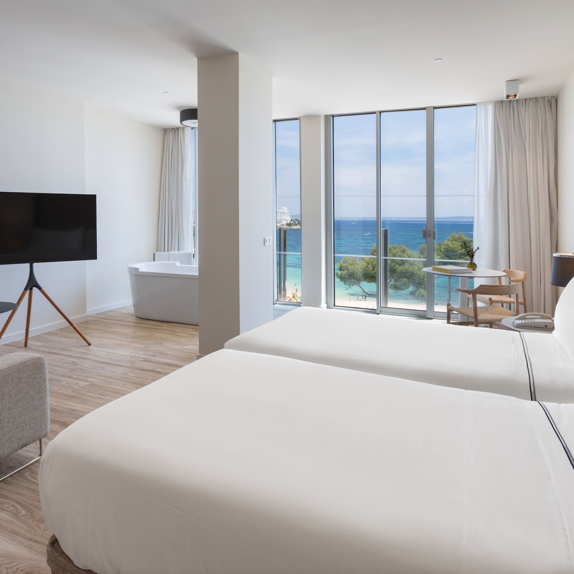 a room with two beds and a tub and a television