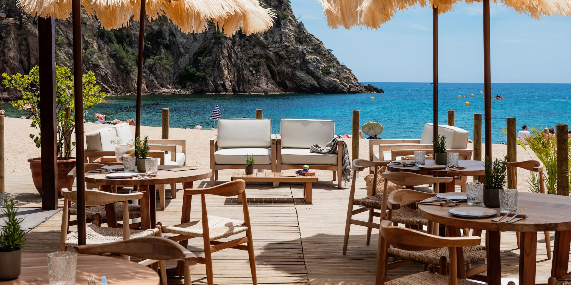 a beach restaurant with tables and chairs and umbrellas
