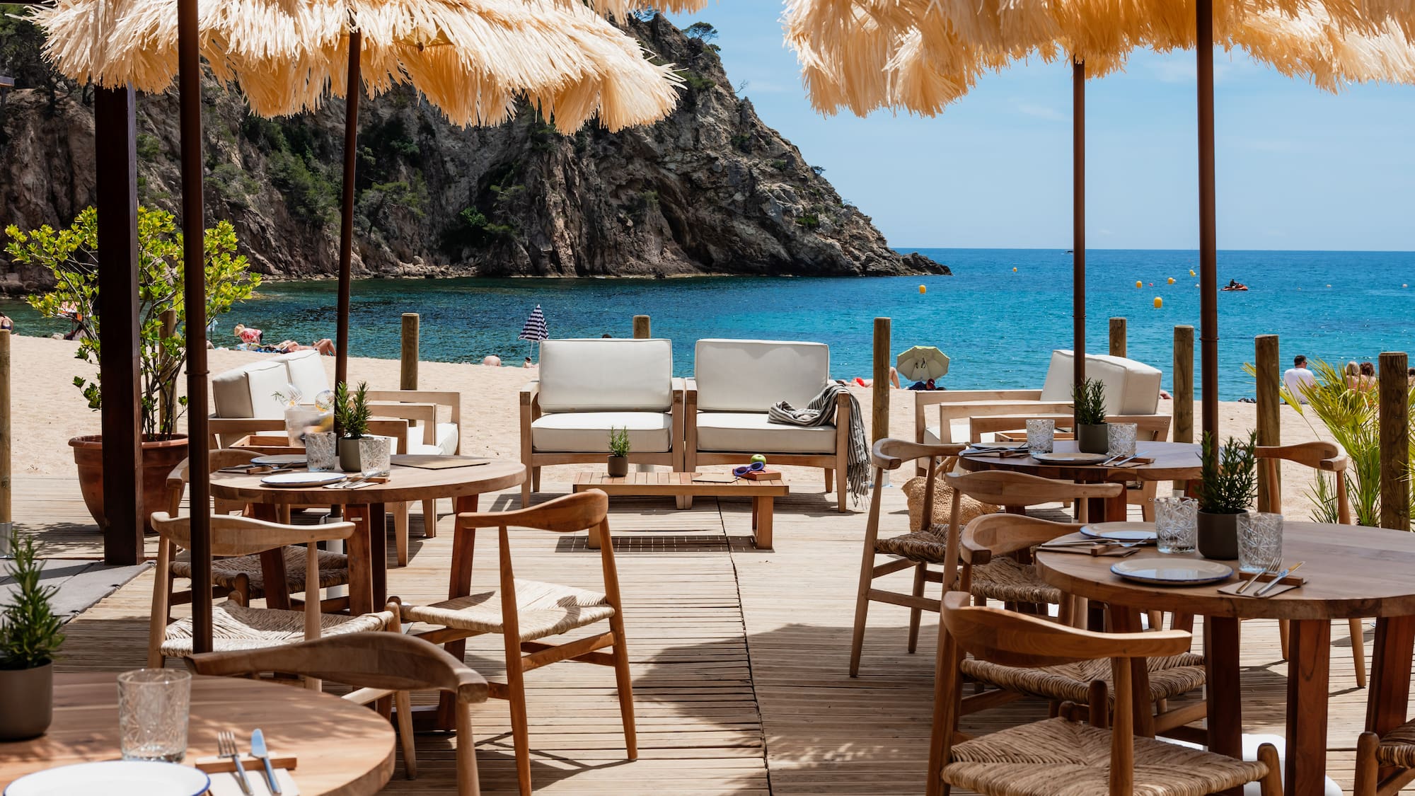 a beach restaurant with tables and chairs and umbrellas