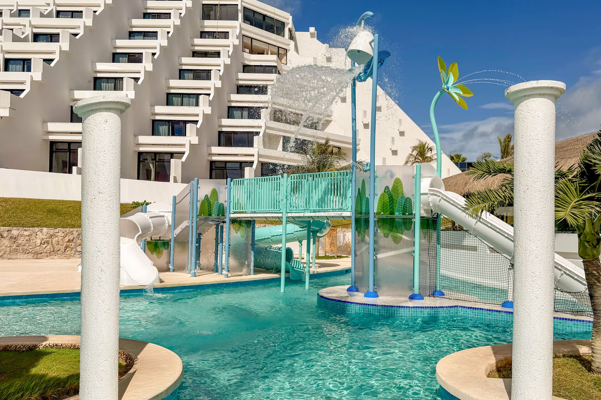 Family resort water park with slides, splash bucket, and tiered hotel.