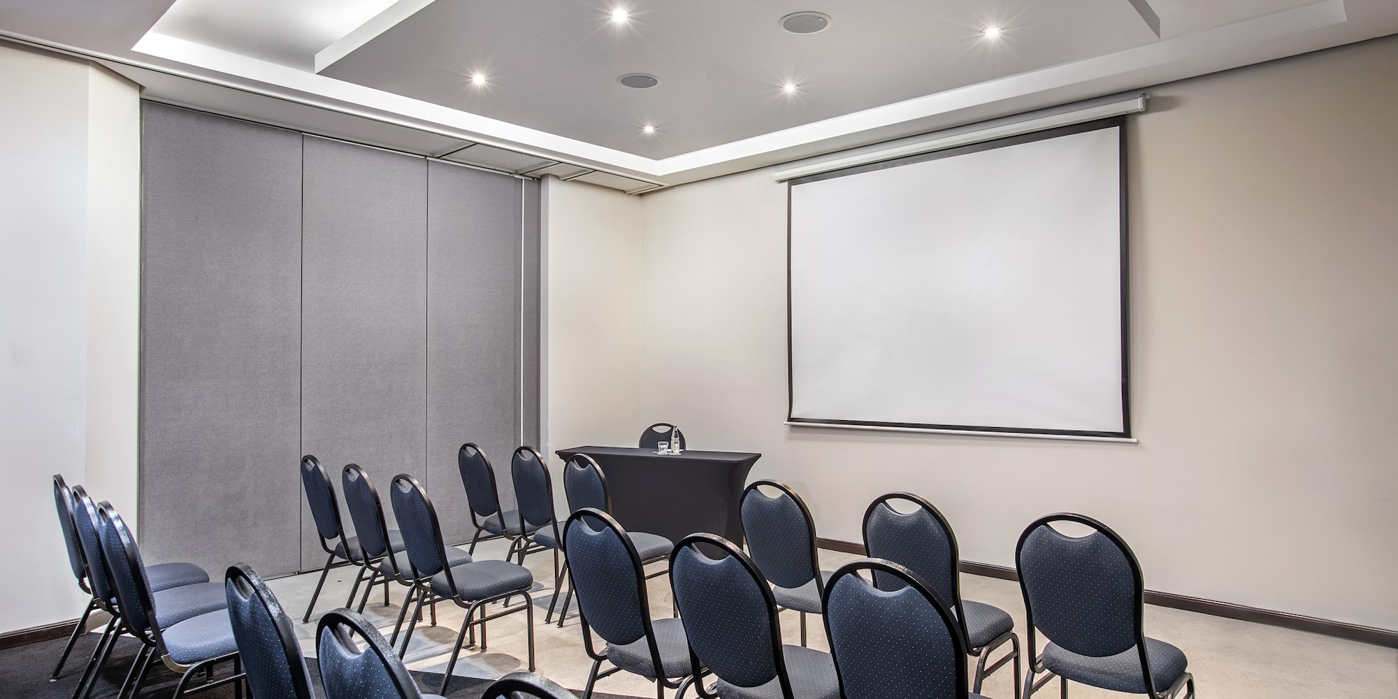 a room with a projection screen and chairs