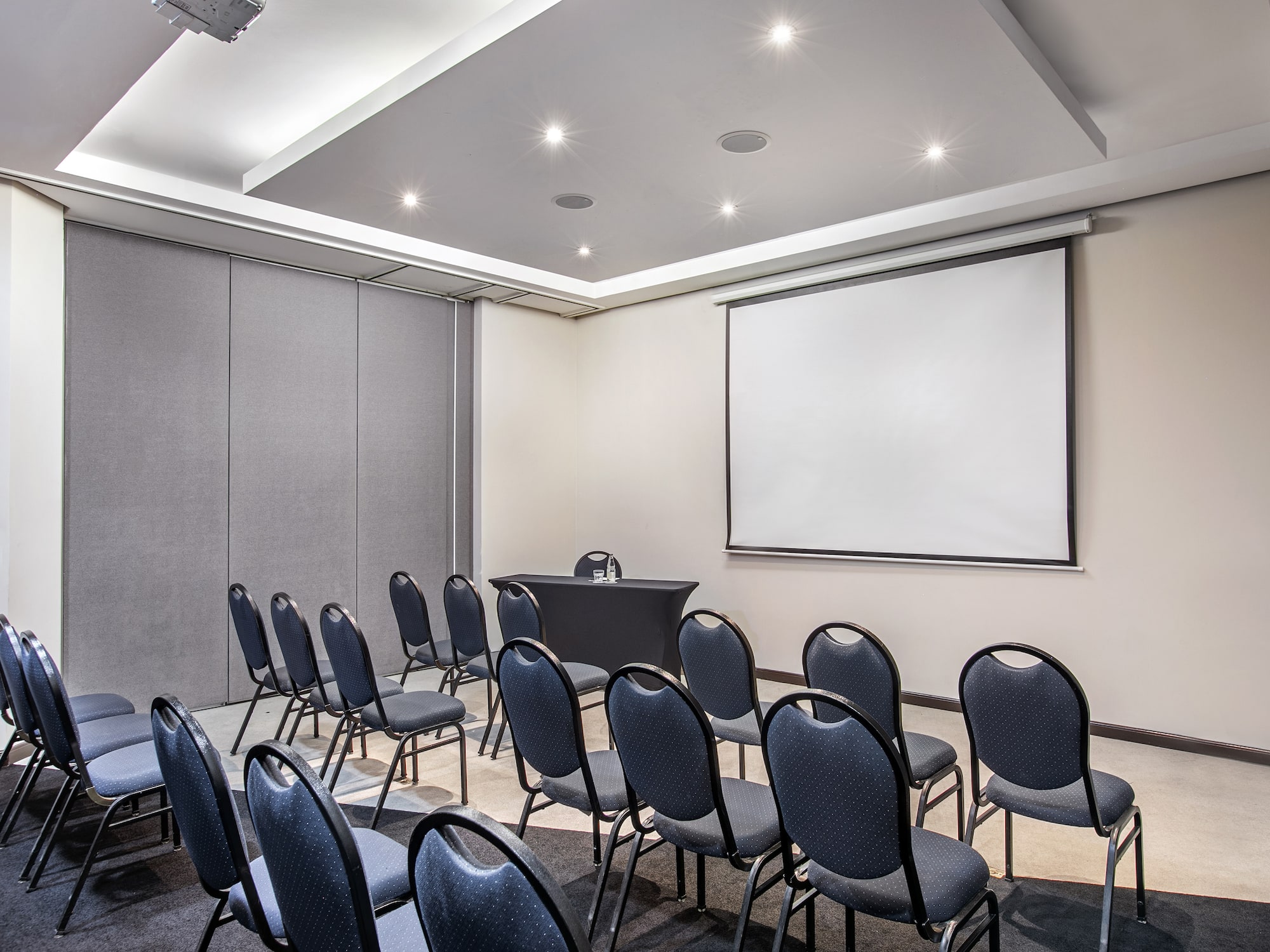 a room with a projection screen and chairs.